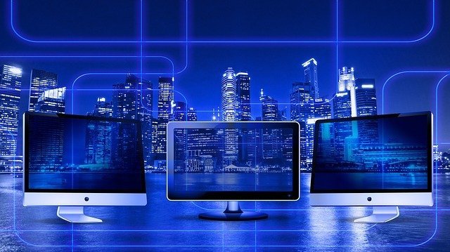3 écrans d'ordinateur sur un fond bleu et des tours de la ville