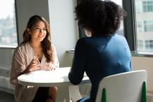 deux femmes qui discutent autour d'une table