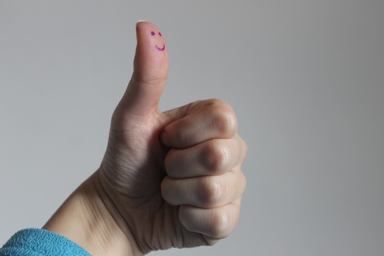 Reconnaissance au travail Un sourire dessiné sur un pouce levé